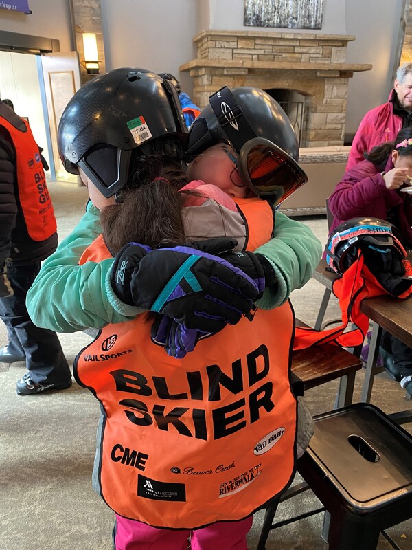 Blind skiers hugging.