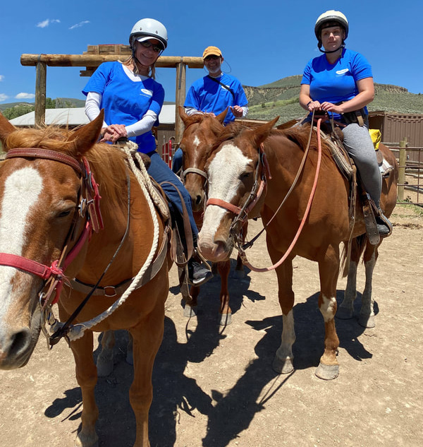 3 people on horses at summer camp