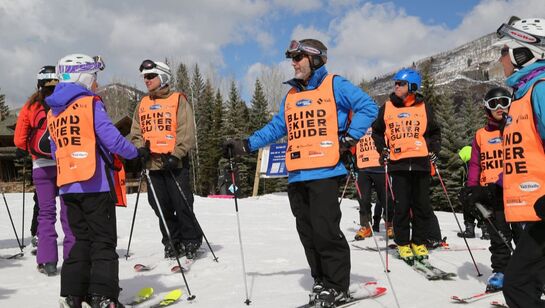 Group of blind skiers and guides in ski gear