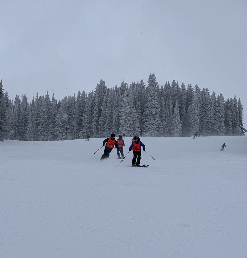 Kevin skiing with guide and shadow on snowy day